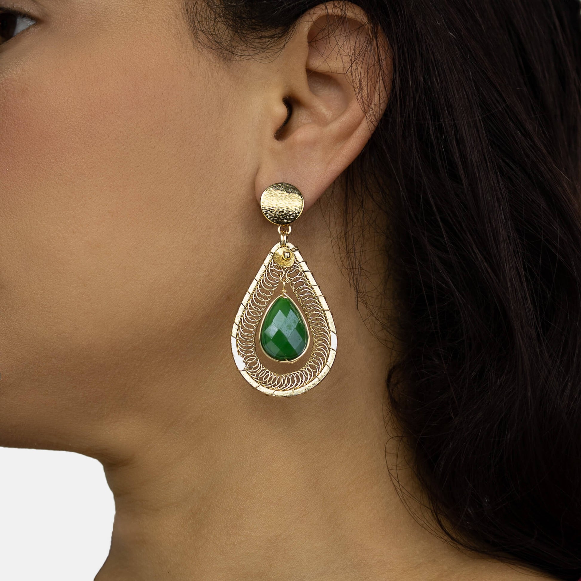 Ganika Earrings on a  model. Gold Color Earrings with Green Teardrop Crystal. Stud Earrings. Metal Frame & Wire Wrapped Earrings. 