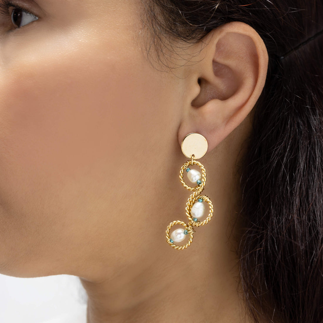 The Mabel Earrings are 2 inches long. Gold, aqua, and white earrings. Wire Wrapped Earrings. Handmade Gold dangle earrings. Feature gold-plated wire, seed bead crystals, and freshwater pearls.