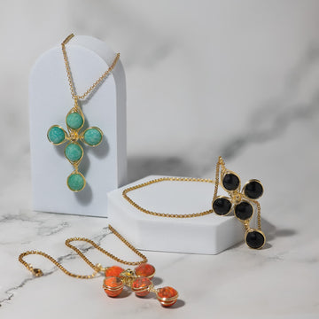 A group of Kazel Wire fashion cross necklaces in gold, each built from polished gemstone beads and hand-worked wire.