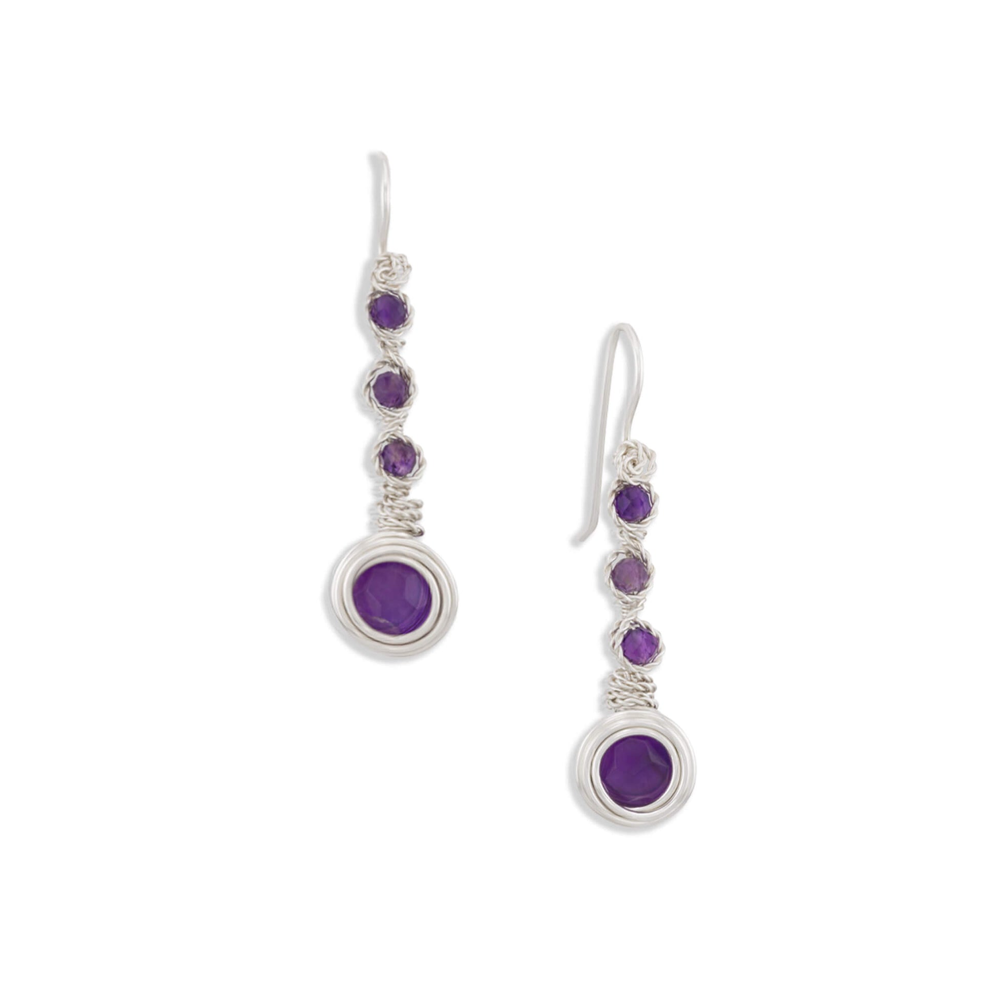 A pair of silver drop earrings featuring a large oval purple stone at the bottom, connected by a short section of smaller round purple stones and textured silver wire, shown on a plain white background.