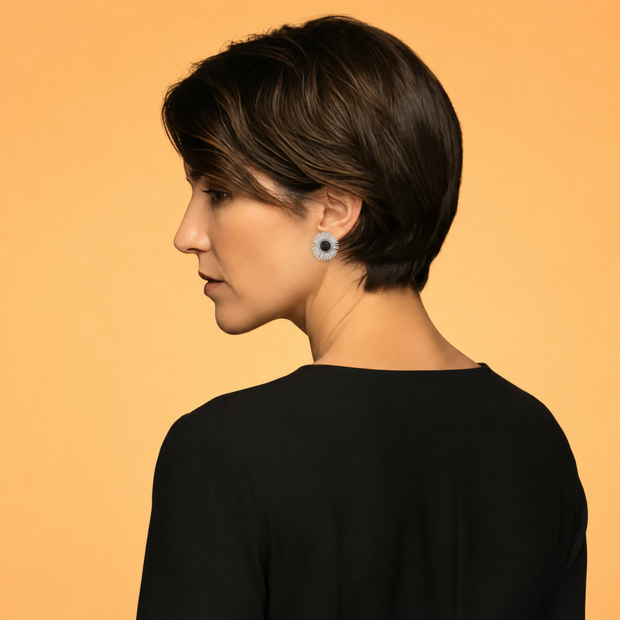 Model wearing silver garnet sunburst stud earrings with a black top