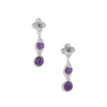 A pair of silver dangle earrings featuring textured flower studs, twisted wire details, and two round purple amethyst gemstones on each earring, set against a plain white background.