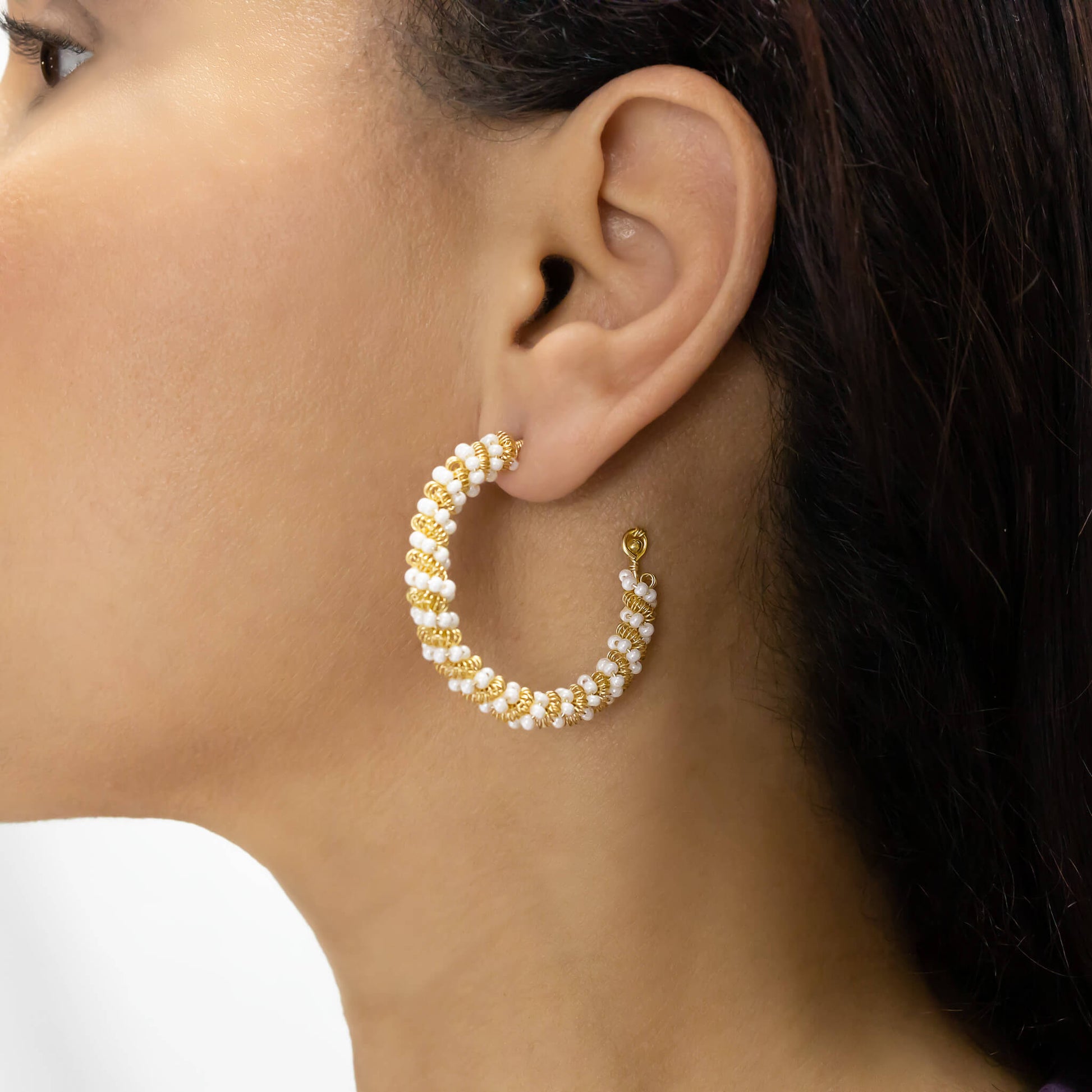 Milan Hoop Earrings on a model. Gold Color Wire with White Seed Crystal Beads.  Wire Wrapped Hoop Earrings.