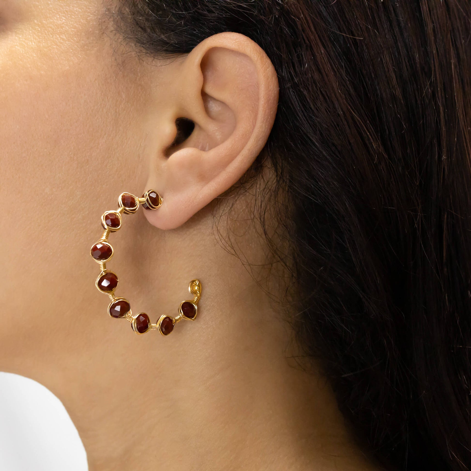 Novara Hoop Earrings on a model. Gold Color Earrings with Dark Red Crystal Beads Wire Wrapped Earrings.