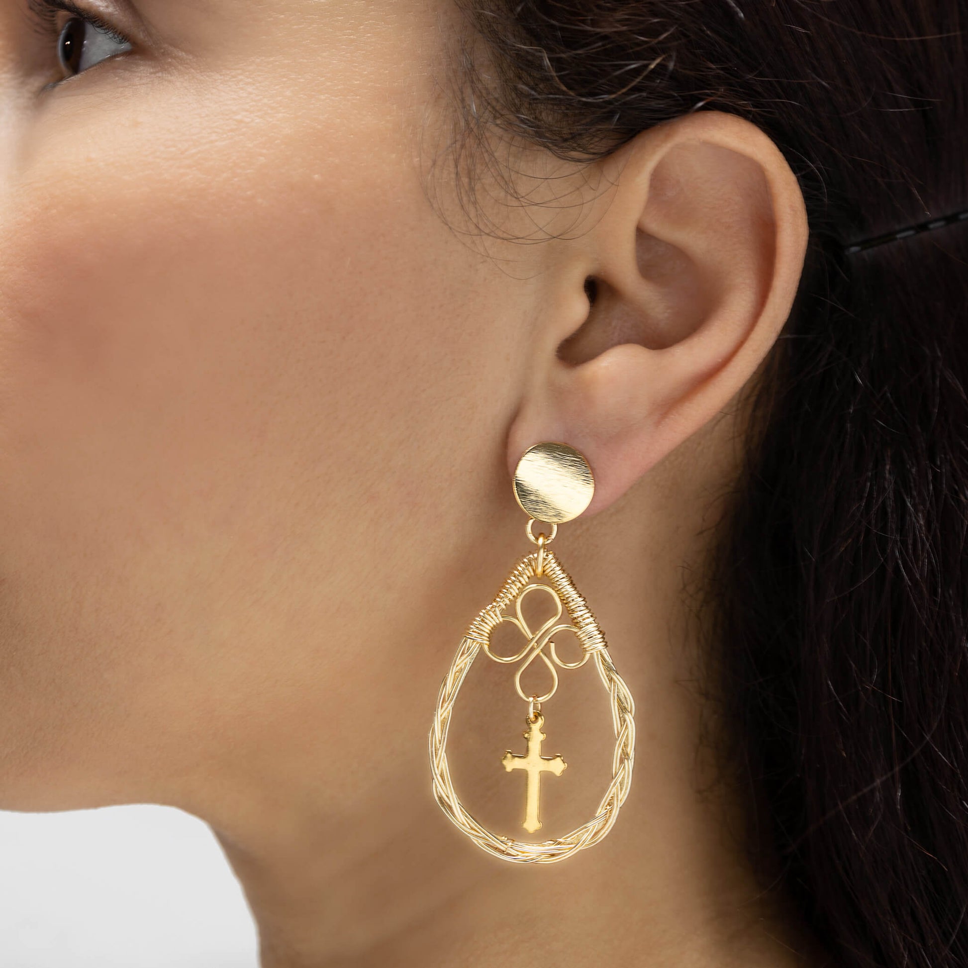 Isha Earrings on a model. Almost 3 inches long. Gold dangle earrings. Handmade with gold-plated wire. Teardrop earrings with a cross charm. Simple Wire Wrapped Earrings